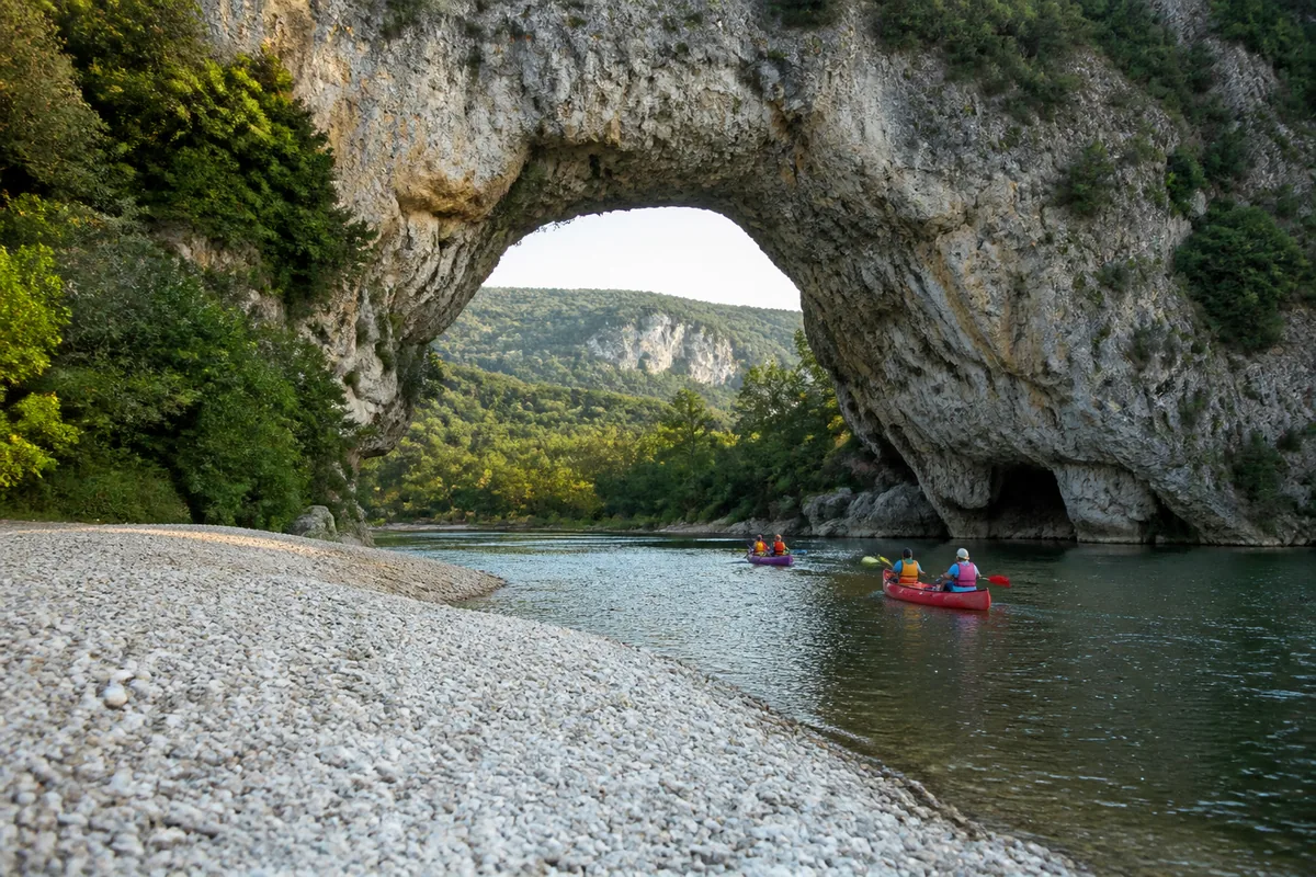 Canoës glissant sur la rivière sous une grande arche naturelle de calcaire