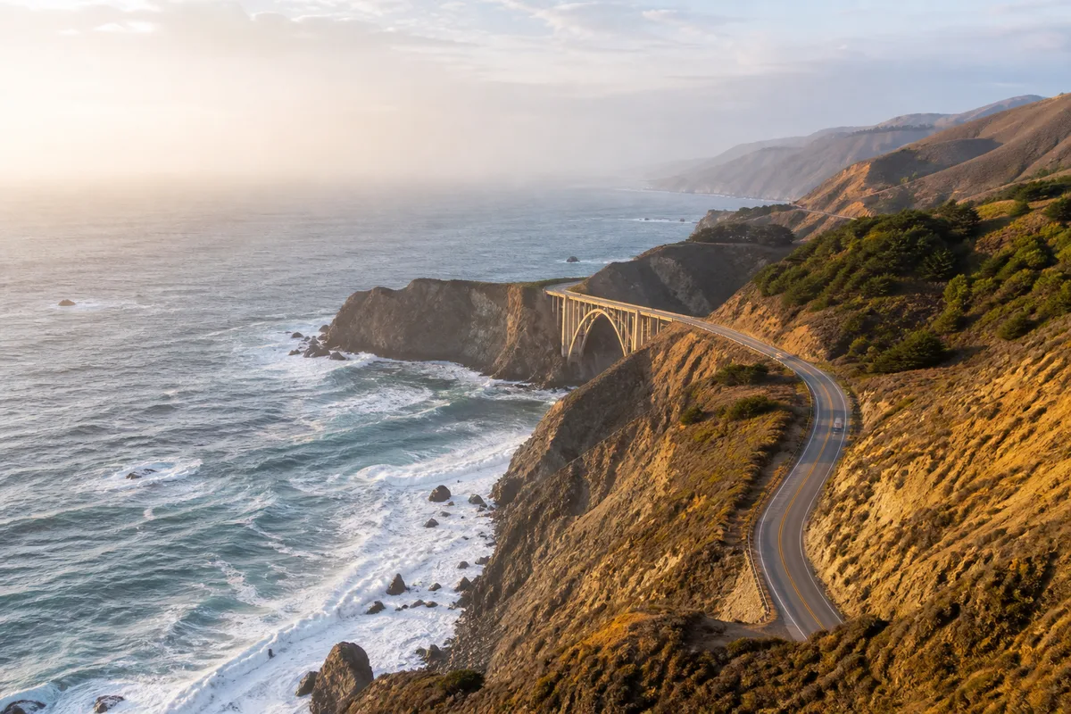 Route côtière sinueuse surplombant l’océan Pacifique sous une lumière de fin de journée