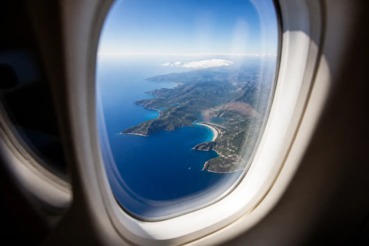 Vue depuis un hublot sur la côte corse découpée et la mer, en approche d&rsquo;atterrissage