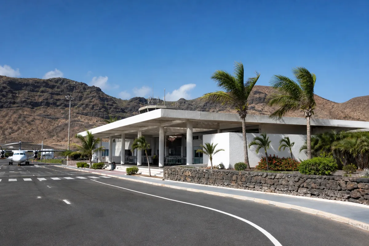 Petit terminal aéroportuaire insulaire vu de l&rsquo;extérieur, palmiers et montagnes