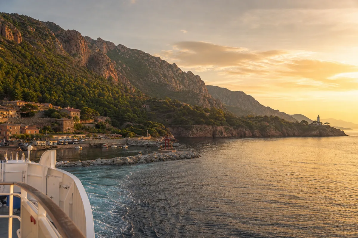 Côte corse vue depuis un ferry approchant du port au coucher du soleil